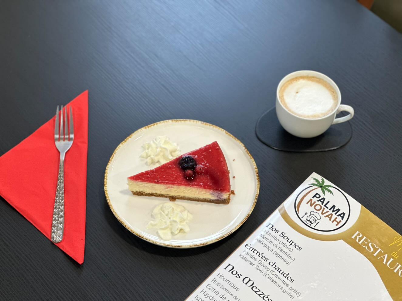 Image du Cheesecake au fruits rouges avec café à côté.